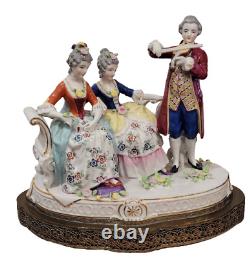 Figurine allemande antique d'un homme jouant du violon avec des dames sur un canapé sur une base en laiton en porcelaine de taille large