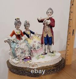 Figurine allemande antique d'un homme jouant du violon avec des dames sur un canapé sur une base en laiton en porcelaine de taille large