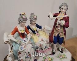 Figurine allemande antique d'un homme jouant du violon avec des dames sur un canapé sur une base en laiton en porcelaine de taille large