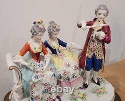 Figurine allemande antique d'un homme jouant du violon avec des dames sur un canapé sur une base en laiton en porcelaine de taille large