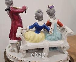 Figurine allemande antique d'un homme jouant du violon avec des dames sur un canapé sur une base en laiton en porcelaine de taille large