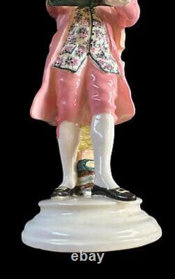 Figurine en porcelaine Goldscheider représentant Mozart lisant un livre avec un violon, en costume rose, antique.