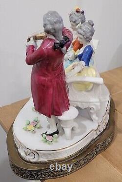 Grande figurine en porcelaine allemande ancienne d'un homme jouant du violon avec des dames sur un canapé sur une base en laiton