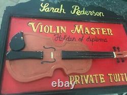 Maître de violon antique Sarah Pedersen : Cours particuliers sur un panneau commercial vintage en forme de violon.