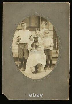 Portrait de famille antique avec un mignon petit chien et un garçon tenant un violon - Photo des années 1900